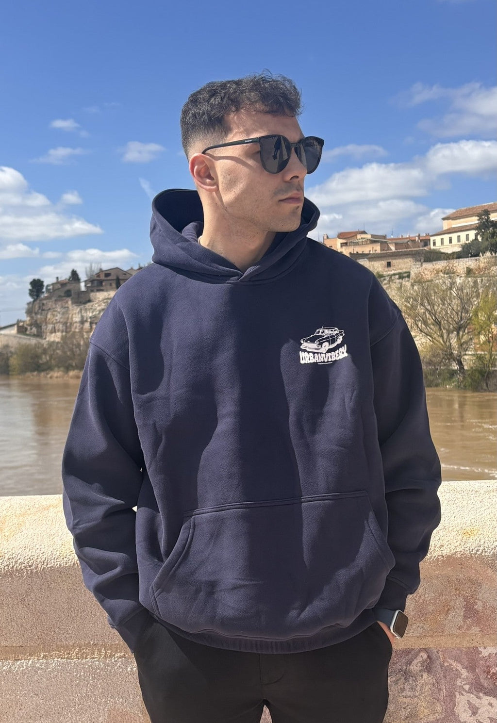 Modelo con Hoodie Urban Essentials azul marino al aire libre - sudadera streetwear oversize unisex UVX Studio